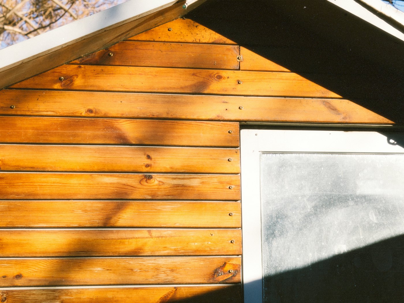 Close-up of cedar lap siding meeting a window frame under a gable